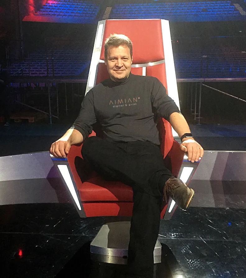 Yrittäjä JP Mäkinen istumassa valmentajan tuolilla